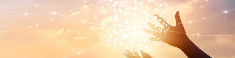 hands holding a glowing ball of light to illustrate the role of managers in creating a positive environment